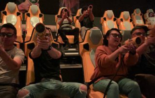 a group enjoying a dark ride theater with 3d glasses and interactive controls
